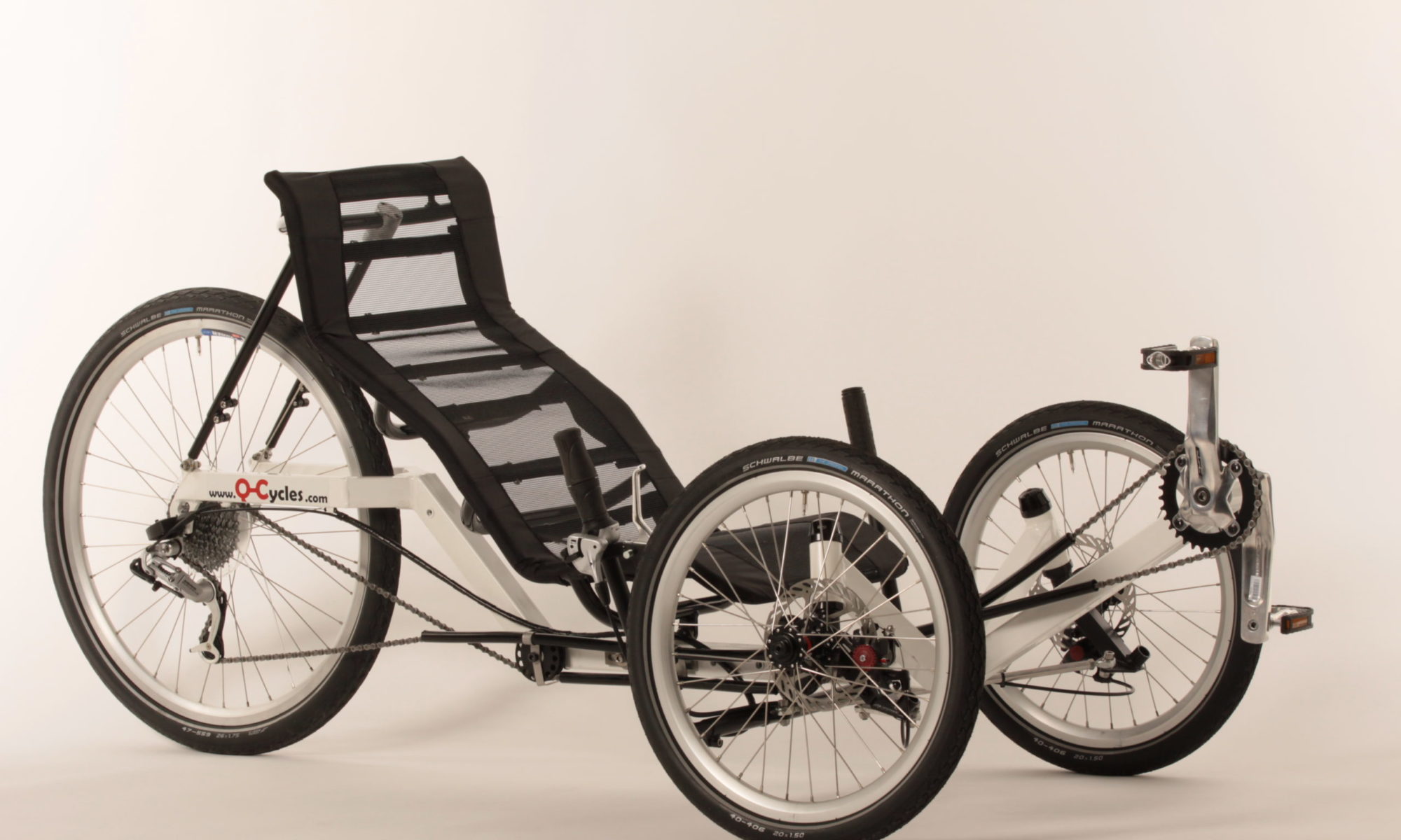 Weißes Q-Cycles-Trike mit schwarzem Netzsitz und drei Speichenrädern